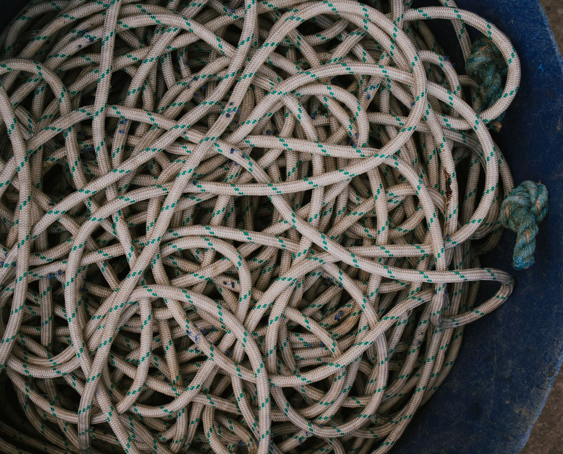 A pile of tangled and textured ropes packed into a blue container