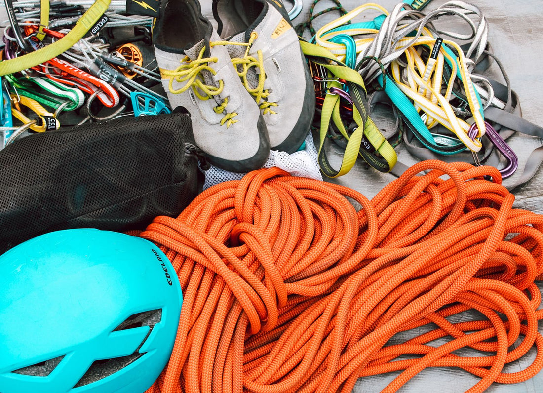 Climbing gear laid out including ropes, helmet, harness and carabiners