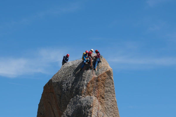 Group of rock climbers together at a summit