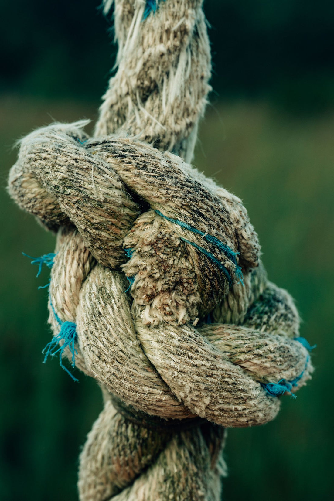 A thick knot tied in weathered rope, the kind of retired climbing rope that gets remade into belts and keychains