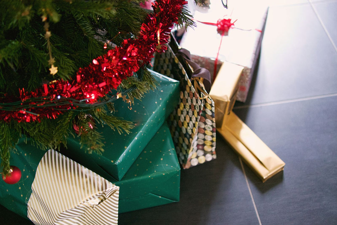 Wrapped Christmas presents piled under a decorated tree