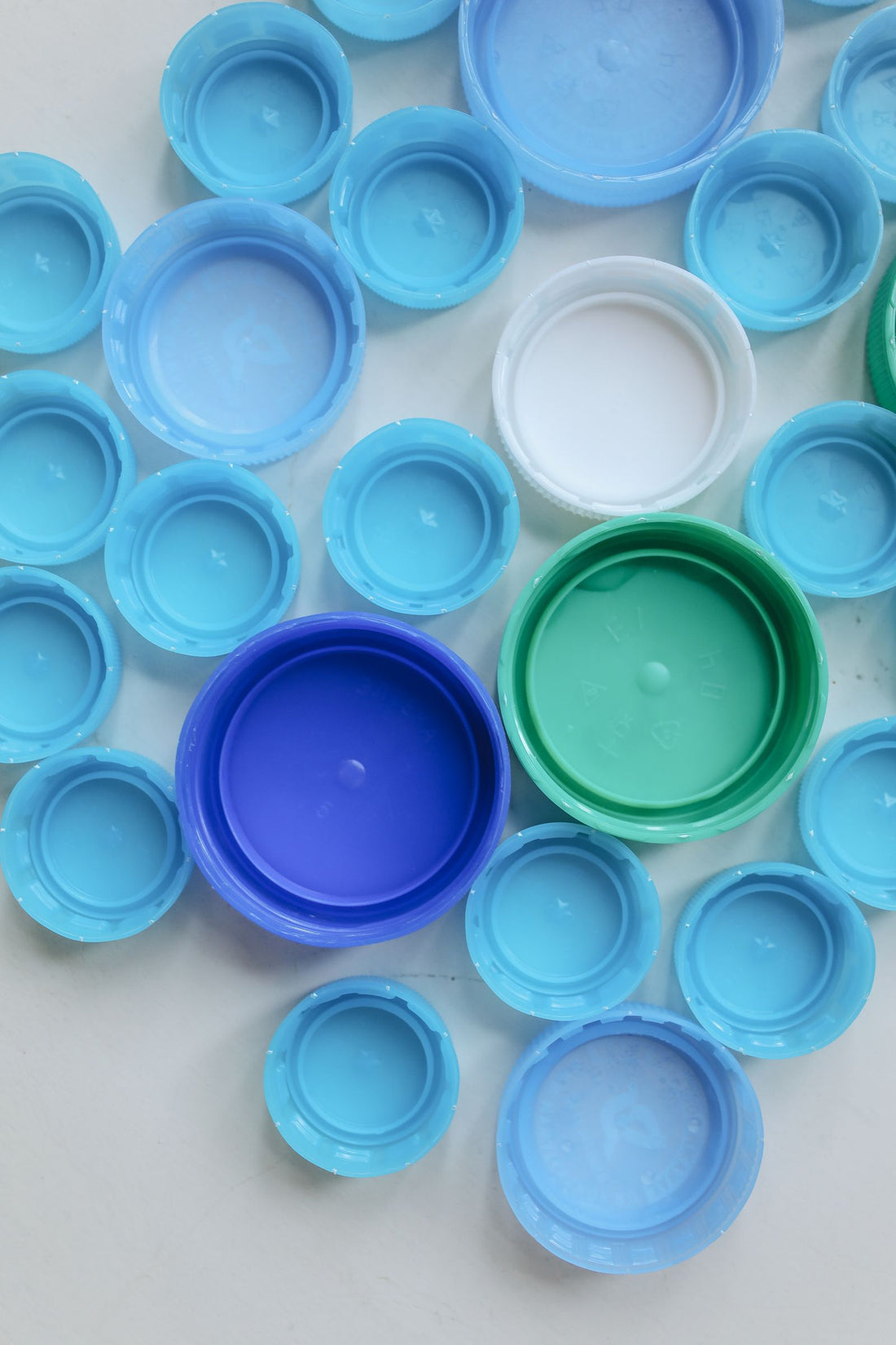 Top down view of assorted colourful plastic bottle caps, the HDPE milk bottle caps and lids used for recycling into new products
