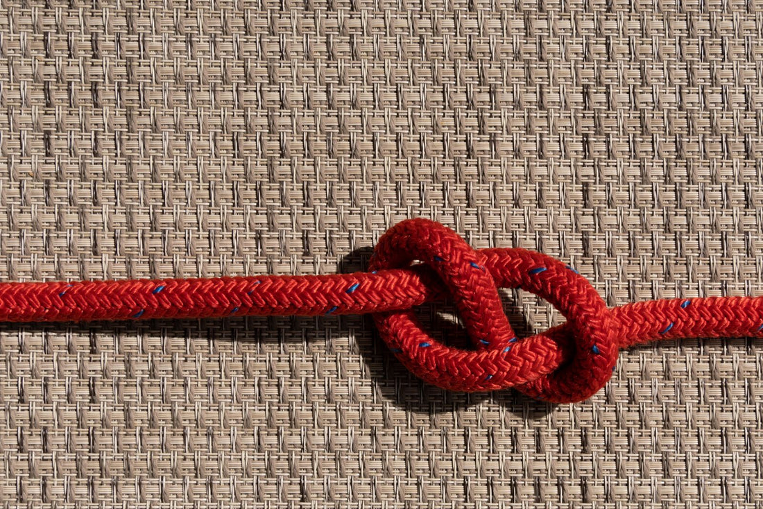 Close-up of a red and orange climbing rope showing the texture of its sheath