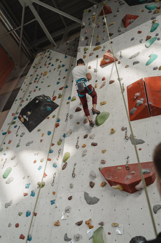 Climber on an indoor climbing wall with colourful holds