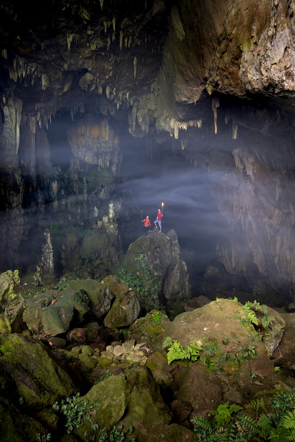 Cavers exploring inside a cave with head torches