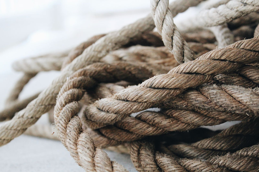 Close-up of thick coiled rope, worn and weathered, showing the texture of the outer sheath