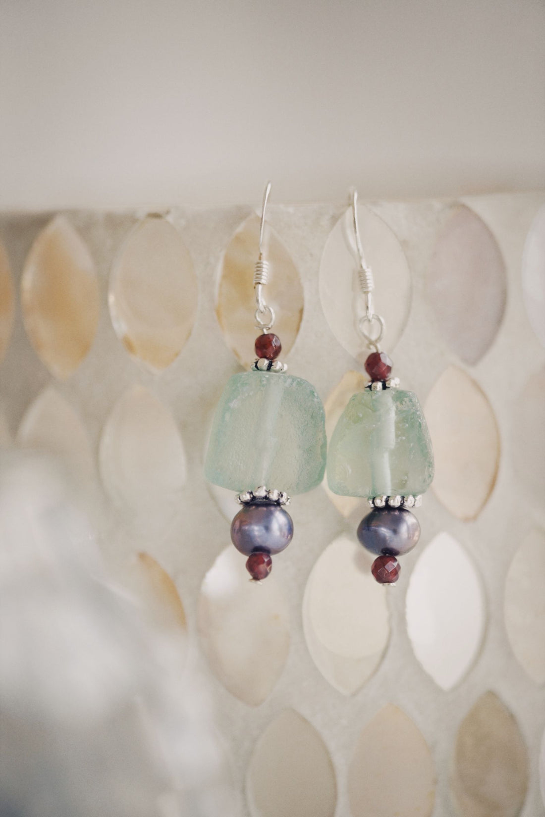 Close-up of handmade beaded earrings, similar in style to Forma's recycled climbing rope earrings